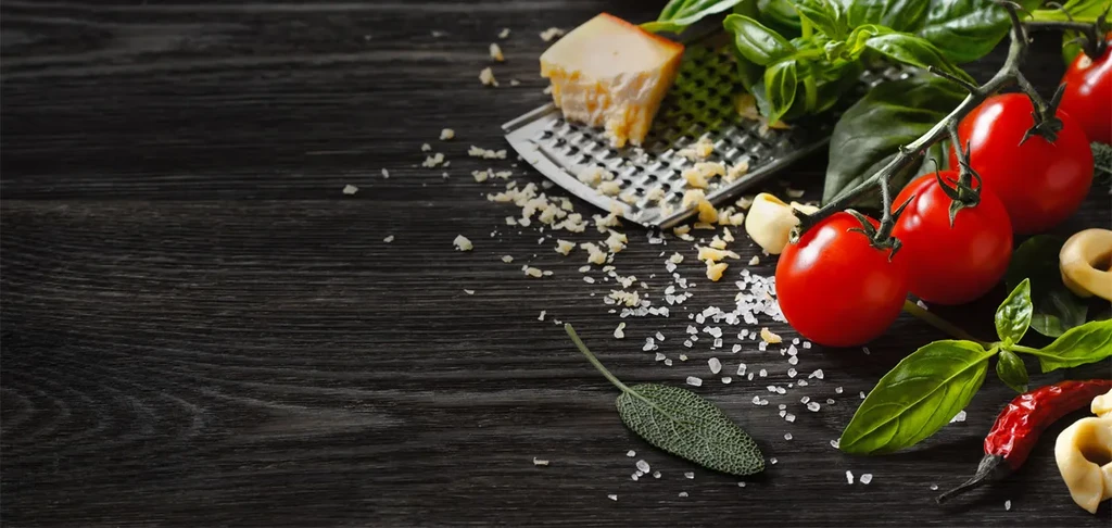Italian ingredients: Parmesan, tomatoes, basil, garlic, on rustic wood.