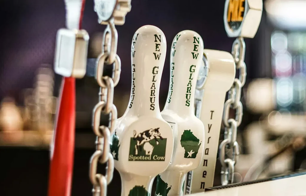 Close-up of white New Glarus Spotted Cow, Wisconsin tap handles.