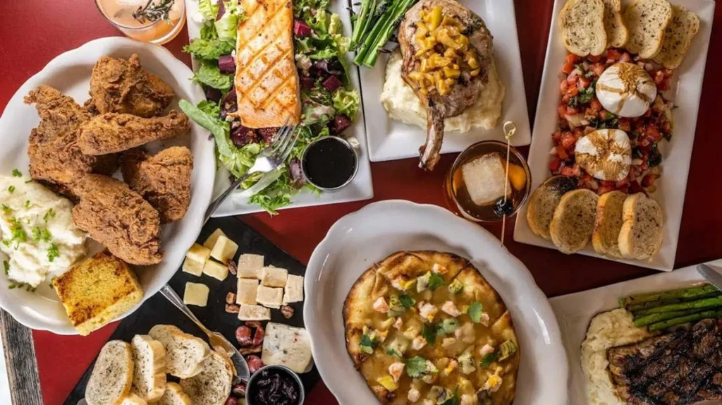 Overhead view of a restaurant table filled with diverse food and drinks.