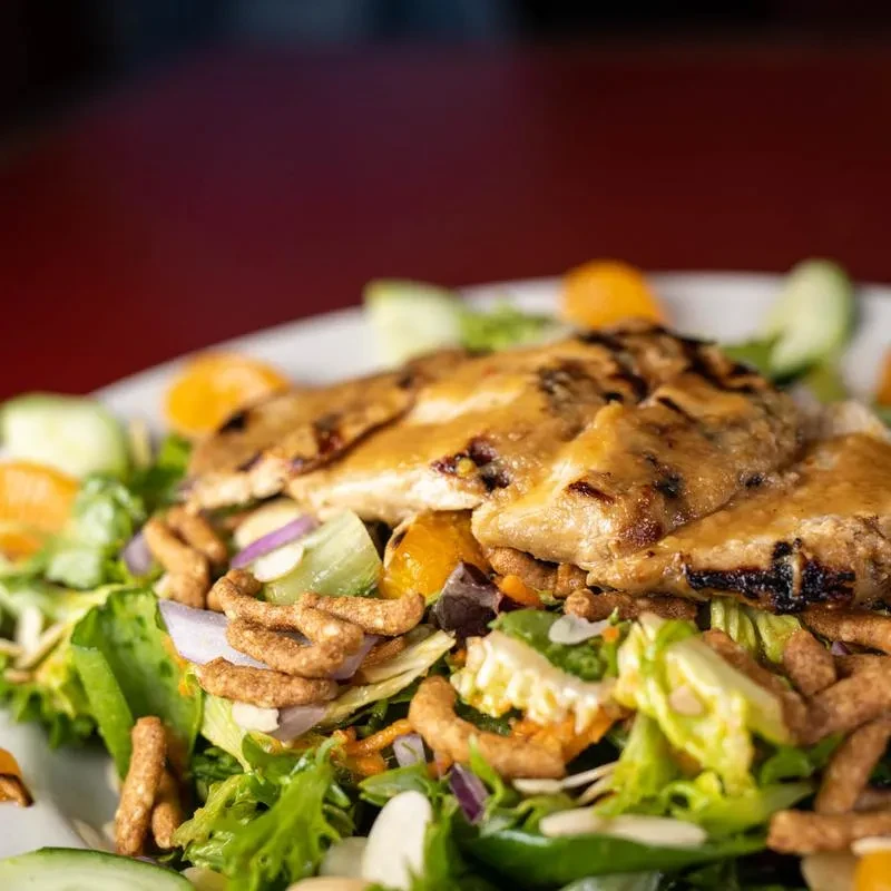 Grilled chicken salad with mandarin oranges, cucumber, and almonds.