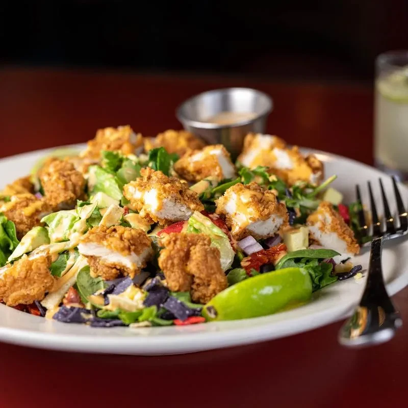 Crispy fried chicken salad with avocado, tortilla strips, and creamy dressing.