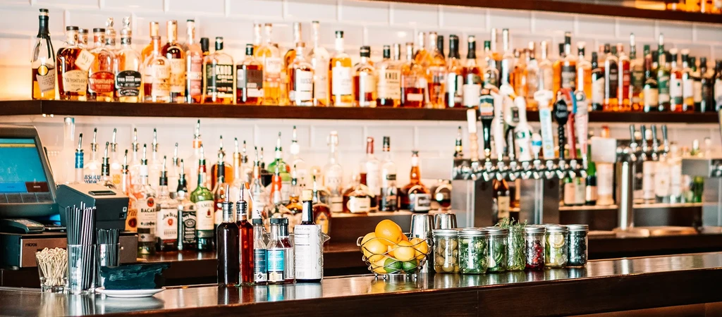 Well-stocked bar with tiered liquor bottles, bar essentials, and beer taps.