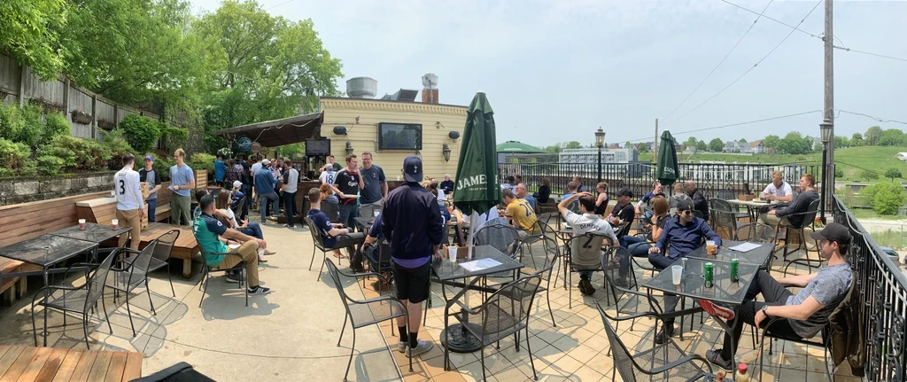 Panoramic view of a bustling outdoor restaurant patio on a sunny day.