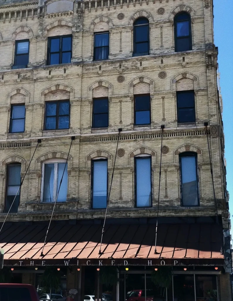 Ornate yellow-brick building with "The Wicked Hop" sign below.