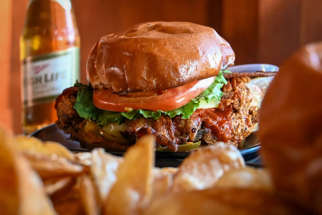 Crispy fried chicken sandwich, fries, and Miller High Life beer.