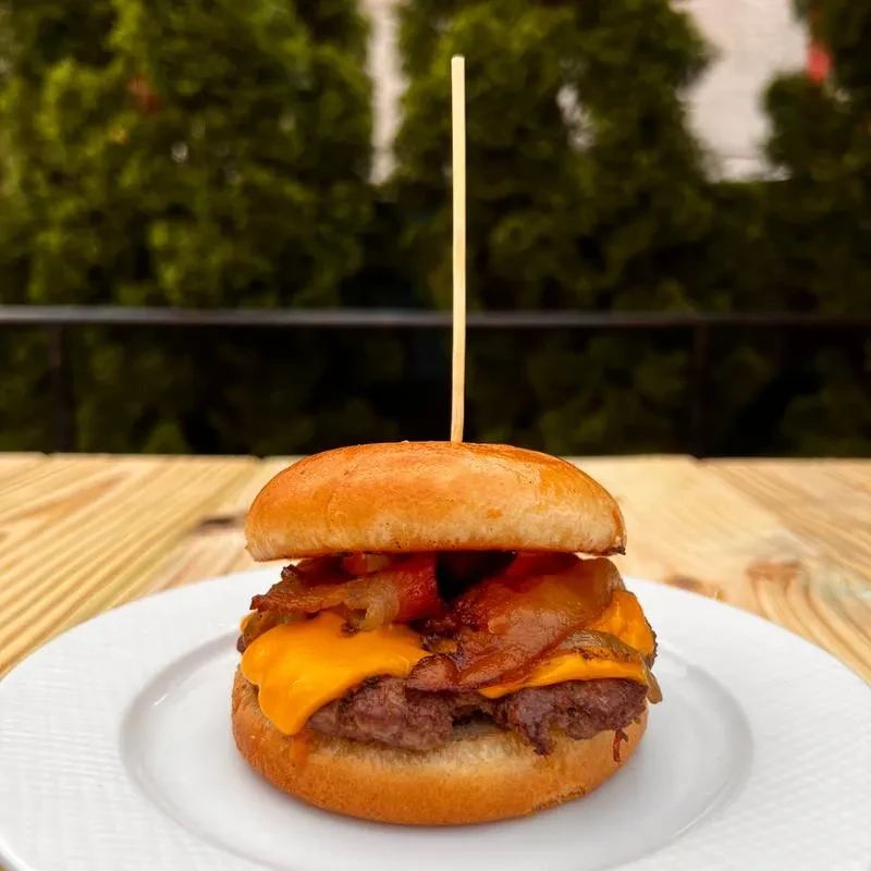 A cheeseburger with bacon, melted cheddar, and caramelized onions.