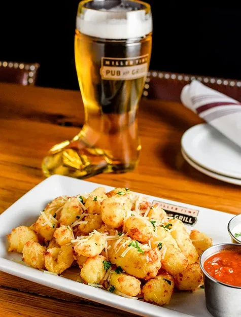 Cheesy fried bites, dips, and Miller Tavern boot glass of beer.
