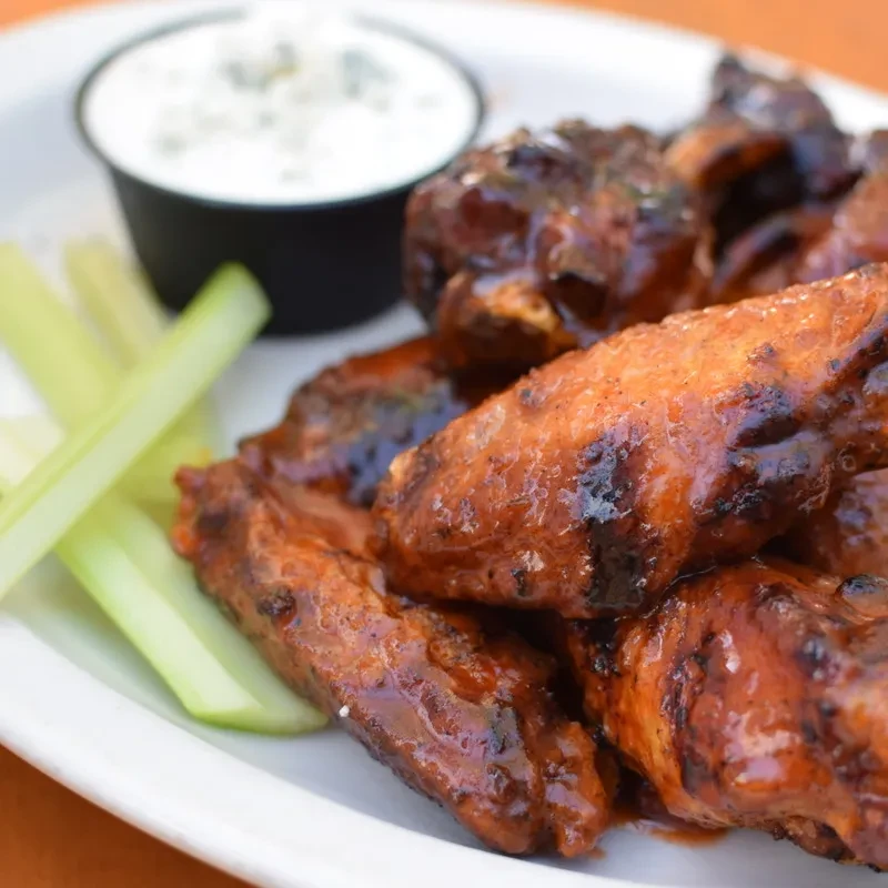 Saucy chicken wings, celery sticks, and blue cheese dip.