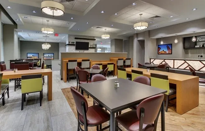 Empty modern restaurant interior with diverse seating and a bar.