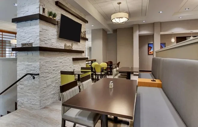 Modern dining area with varied tables, chairs, and long booth.