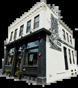 Two-story "Black Sheep Whiskey Distillery" building with a black and white exterior.