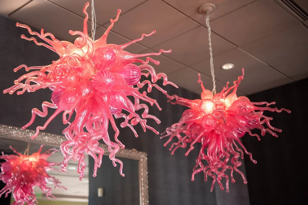 Two ornate pink and red coral-like glass chandeliers.