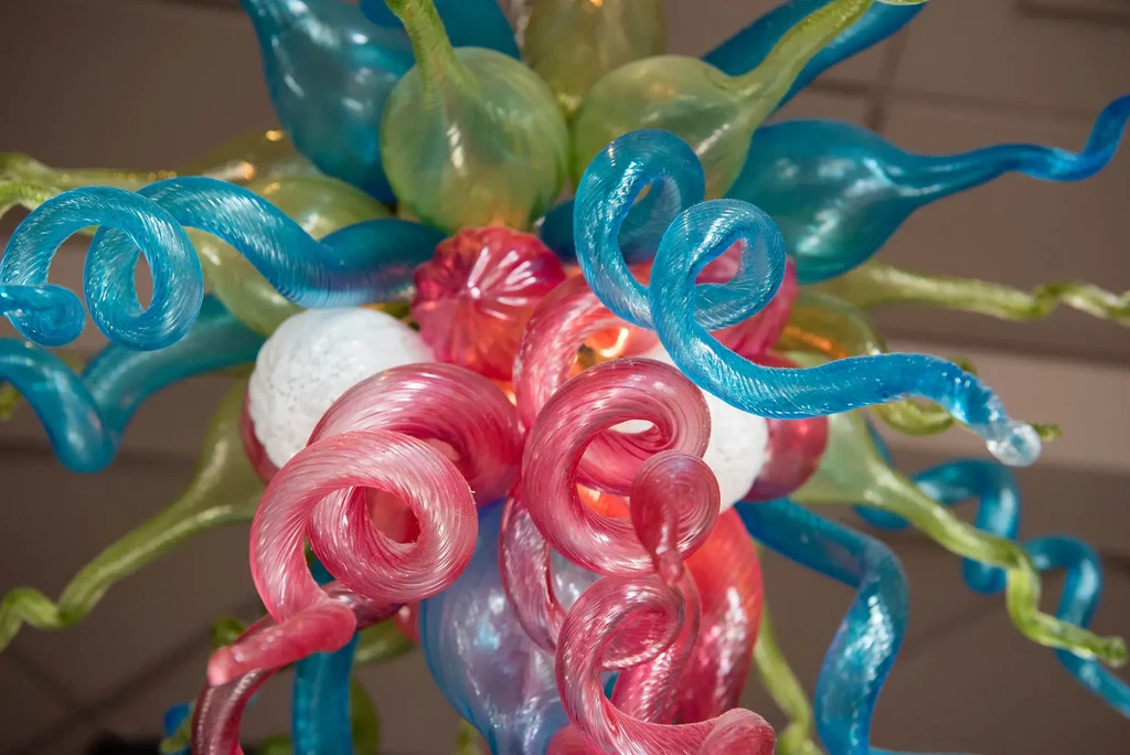 Vibrant blown glass art sculpture in turquoise, lime green, and fuchsia.