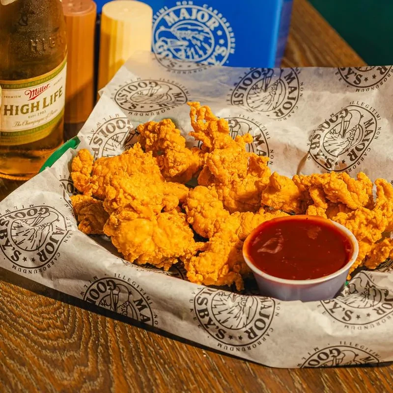 Crispy fried chicken, dipping sauce, beer, and Goosby's branded packaging.