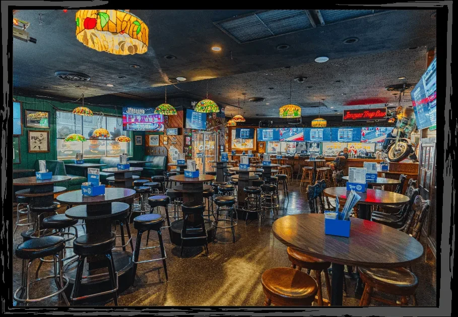 Jacques Tap Bar interior with Tiffany lamps, TVs, and suspended motorcycle.