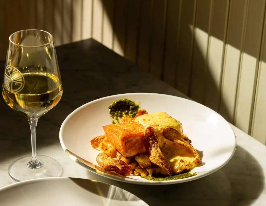 Crispy-skinned salmon, roasted vegetables, two sauces, and white wine.