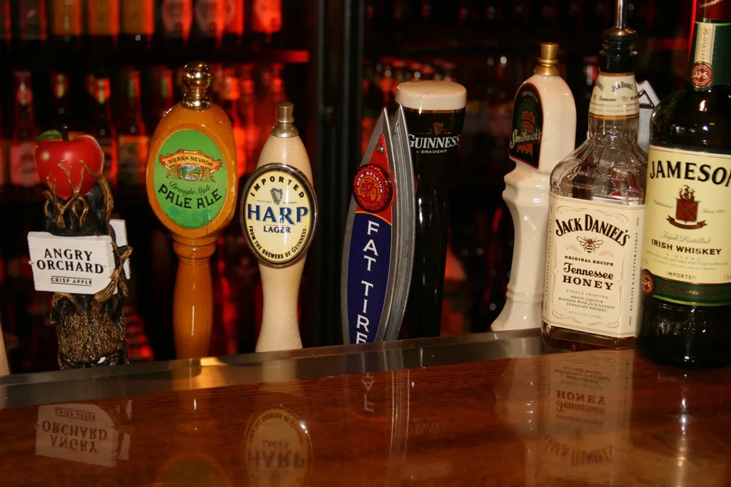 Well-stocked bar counter with multiple beer taps and whiskey bottles.