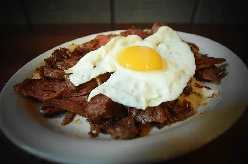 Corned beef hash topped with a sunny-side-up egg.