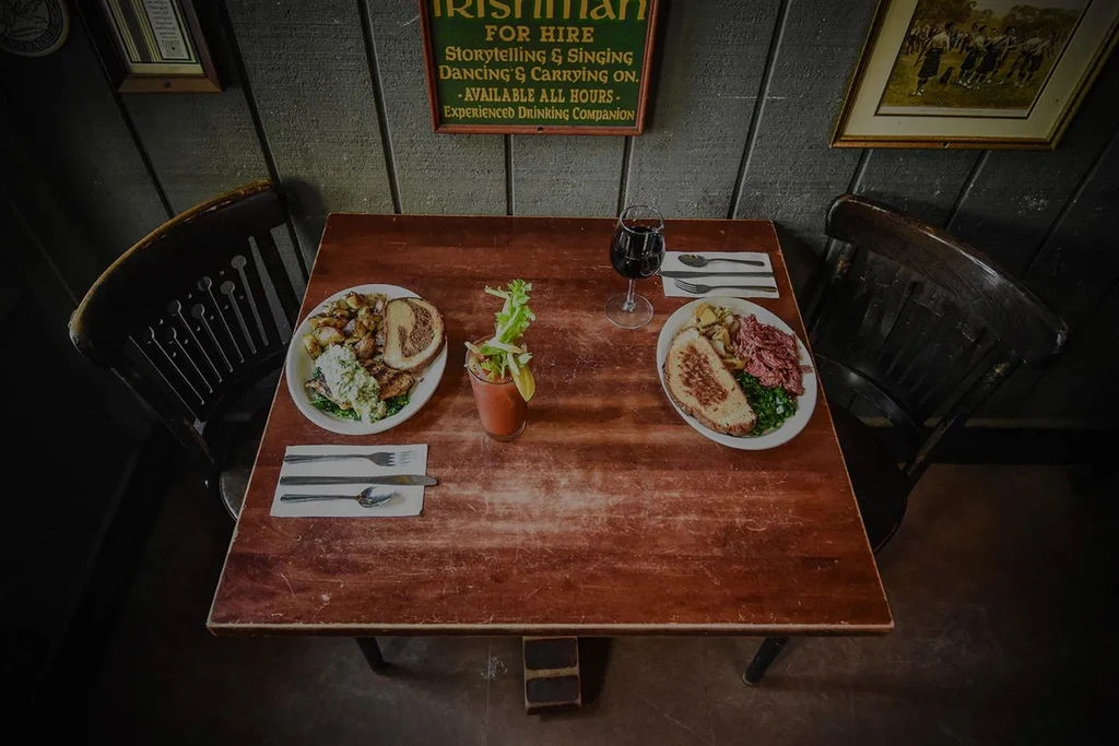 Rustic Irish pub table with two hearty meals and drinks.