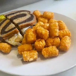 Grilled cheese on marbled rye, pickle spear, and crispy tater tots.
