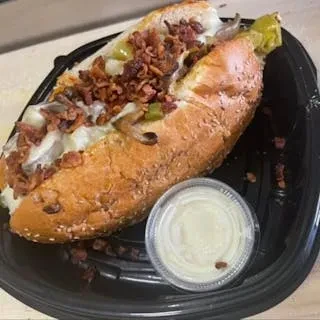 Hoagie with meat, melted cheese, onions, peppers, bacon, and dipping sauce.