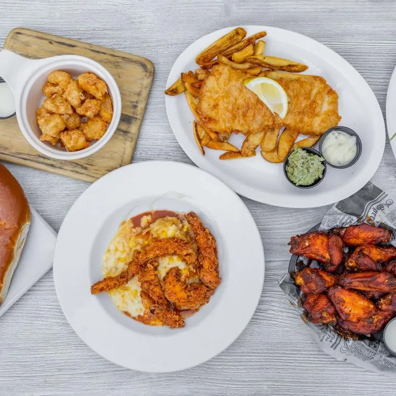 Top-down view of various fried comfort foods on a wooden table.