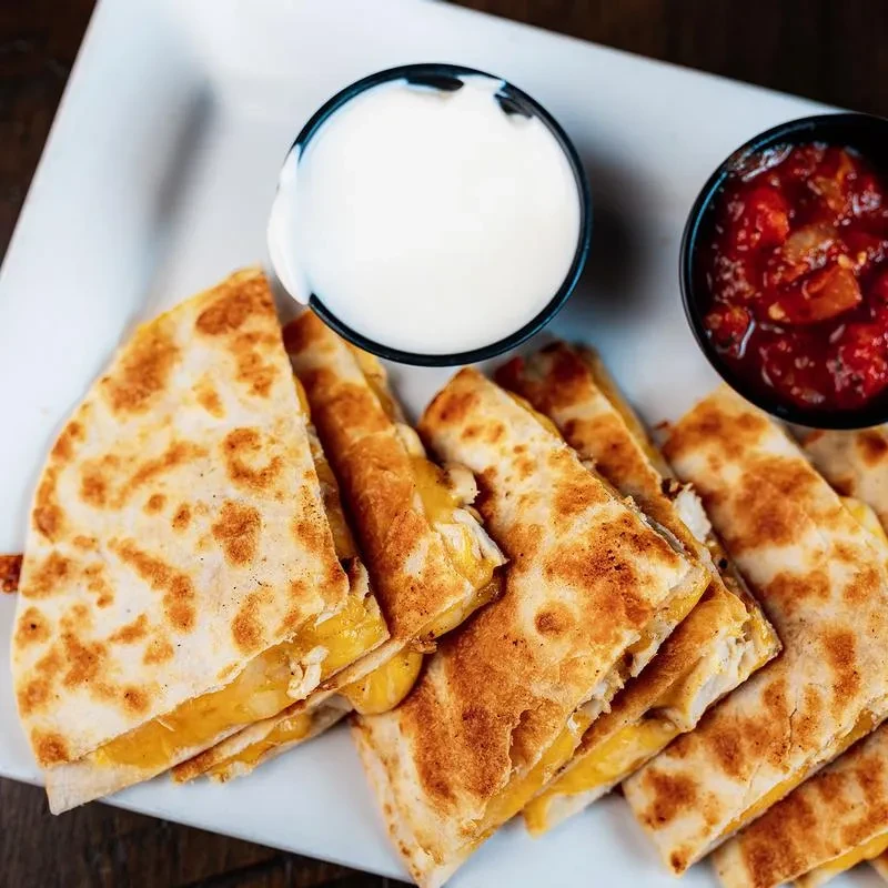 Golden brown quesadilla wedges, melted cheese, sour cream, chunky salsa.