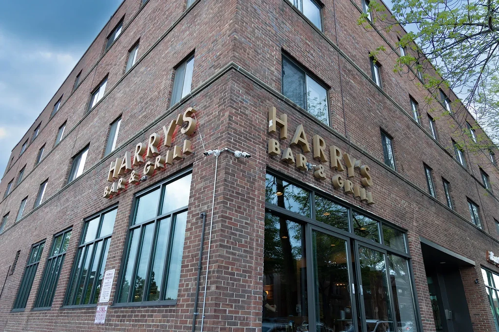 Harry's Bar & Grill sign on a multi-story brick building corner.