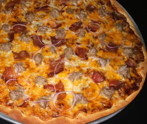 Generously topped sausage, bacon, and red onion pizza.