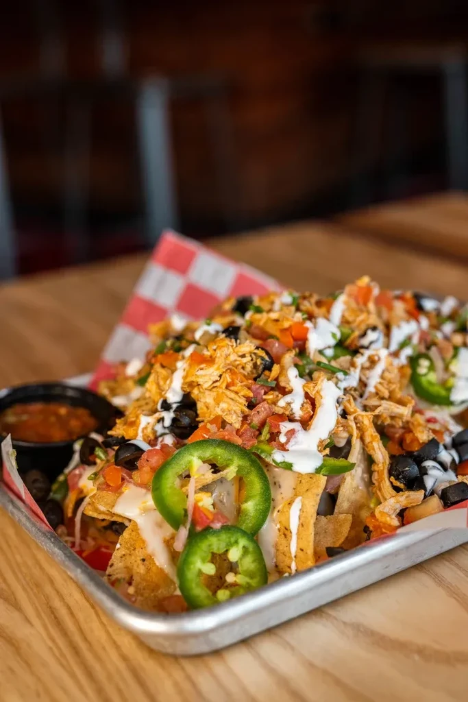 Generous serving of nachos with cheese, jalapeños, meat, and pico de gallo.