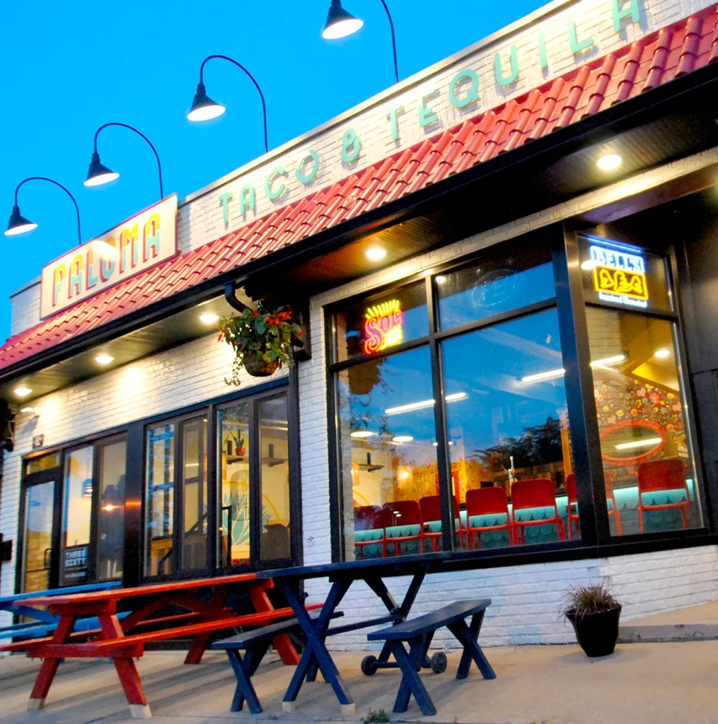 Paloma Taco & Tequila restaurant exterior with picnic tables at dusk.