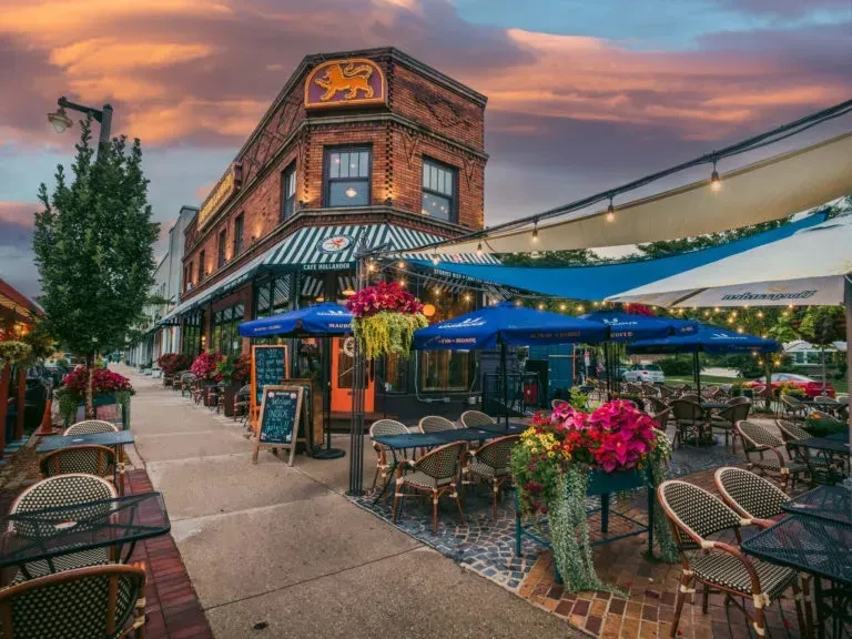 Cafe Hollander's outdoor patio and brick building under a colorful sunset.