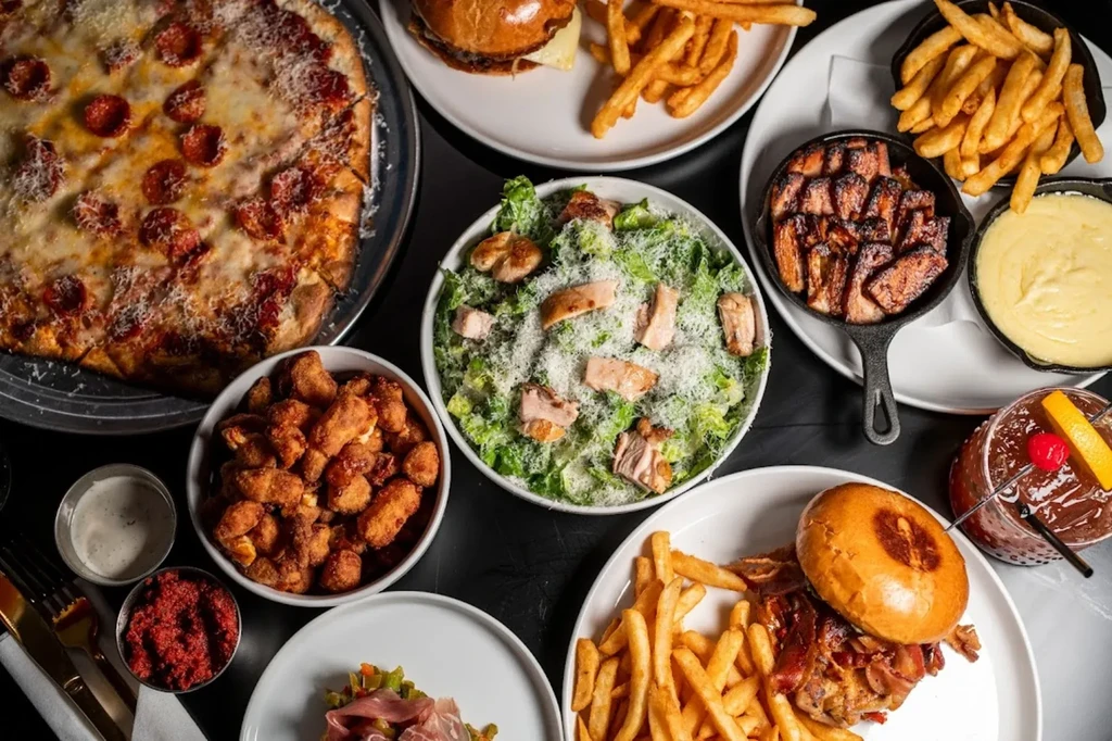 Overhead view of a table spread with various restaurant dishes and drinks.