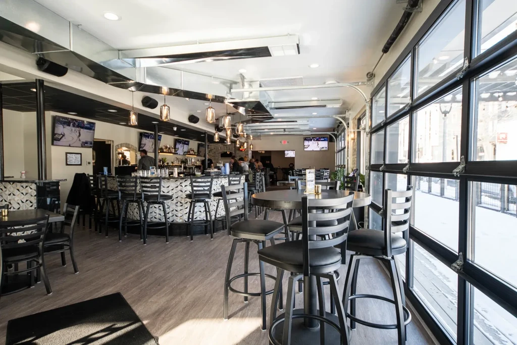 Modern industrial-chic bar with patterned U-bar and snowy view.