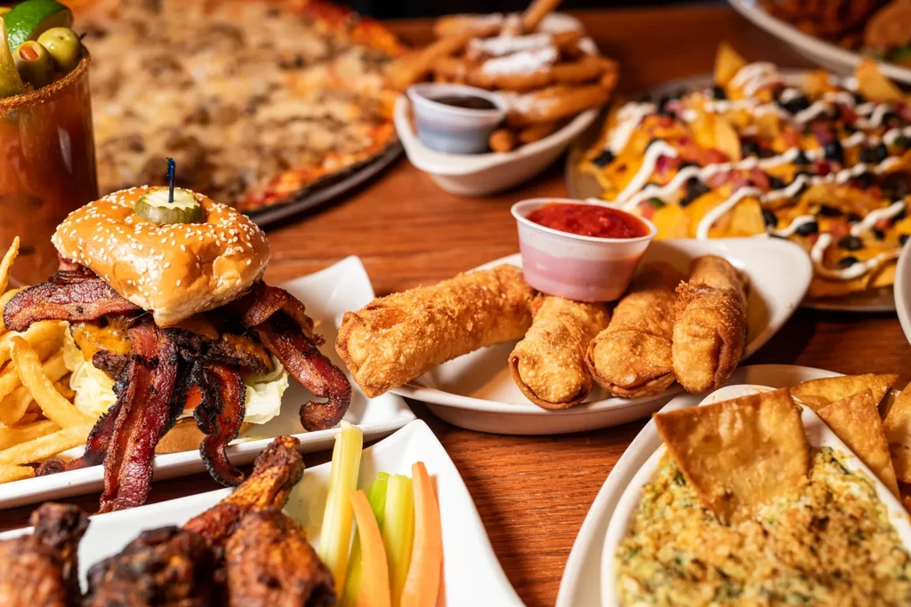 Table laden with a variety of comfort food dishes and drinks.