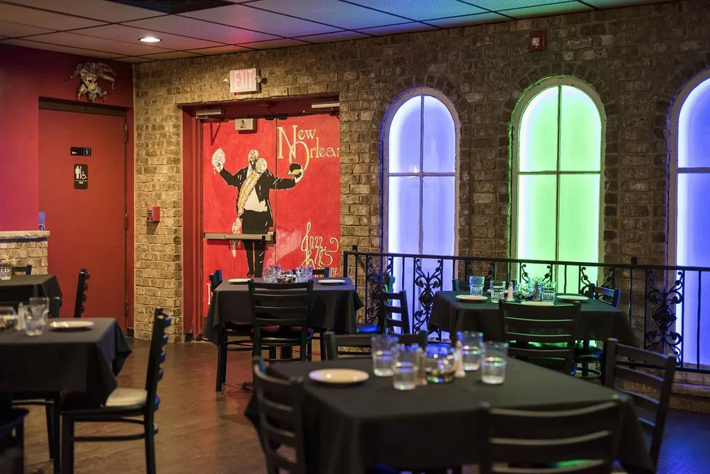 Restaurant interior featuring brick, set tables, and colorful LED arches.