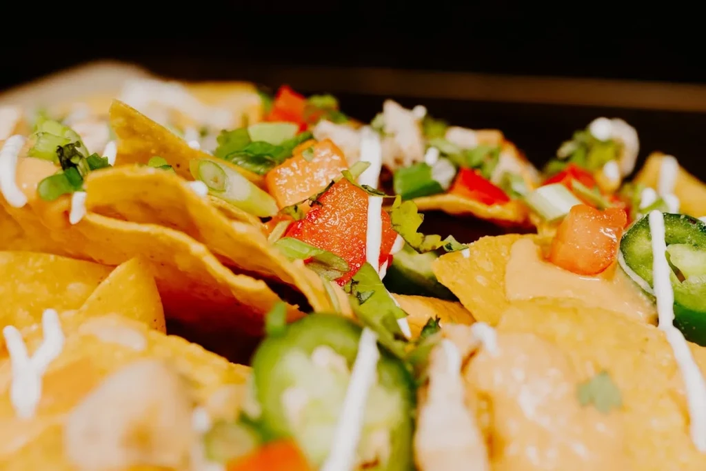 Crispy nachos topped with melted cheese, tomatoes, green onions, and jalapeños.