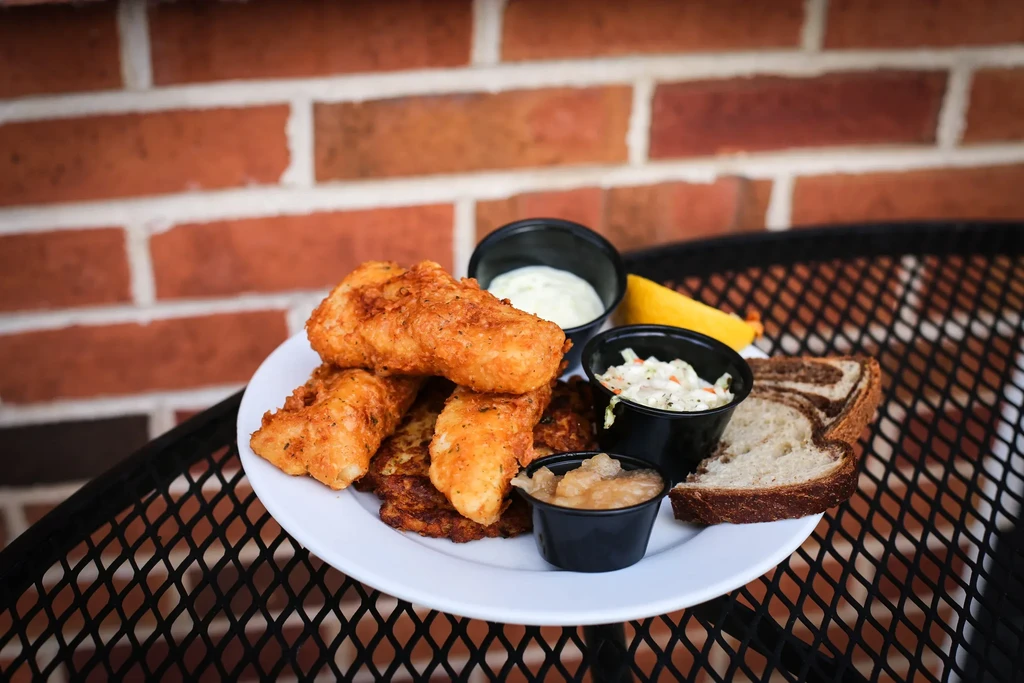 Fried fish, potato pancakes, coleslaw, sauces, lemon, and rye bread.