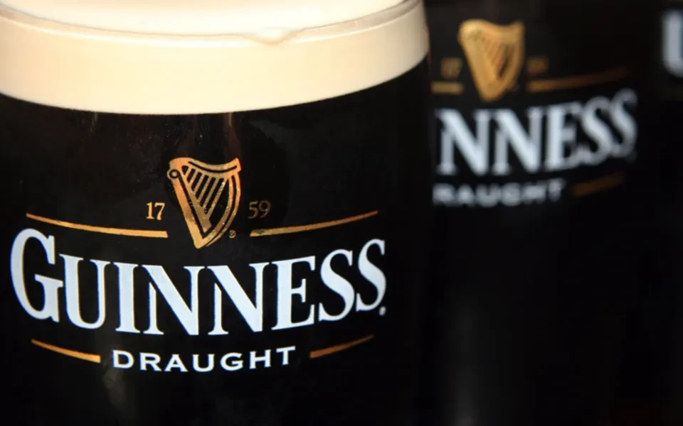 Close-up: Guinness Draught beer pint with creamy white head.