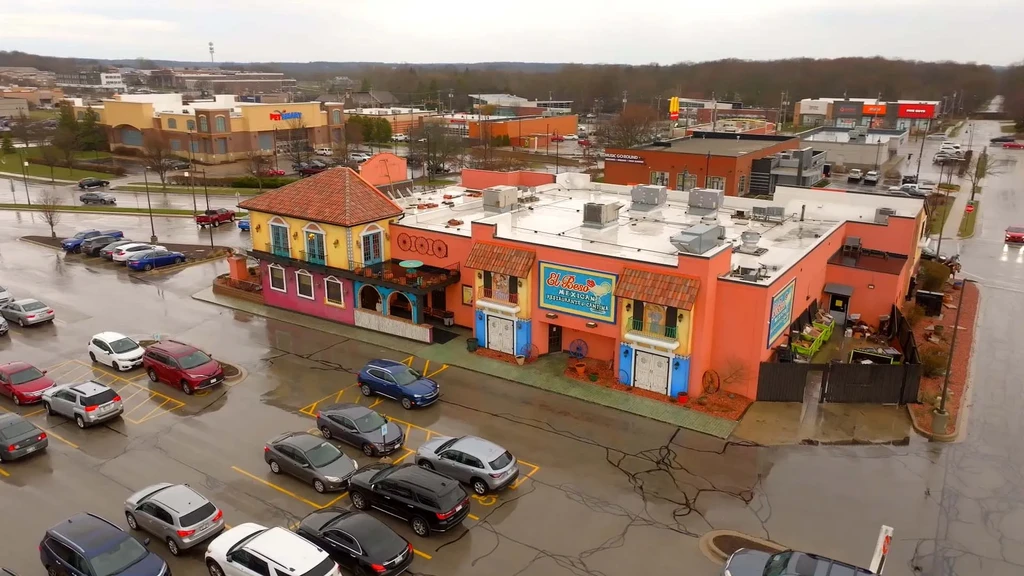 Aerial view of vibrant El Beso Mexican restaurant and full parking lot.