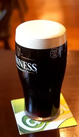 Guinness Draught pint glass with creamy white head.