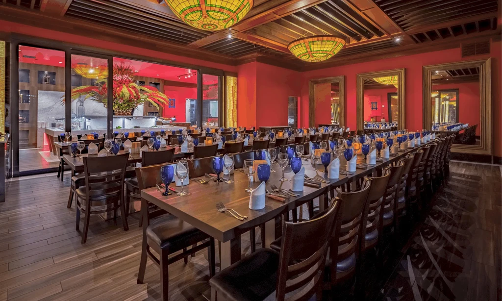 Grand red dining room, set tables, stained-glass dome lights.