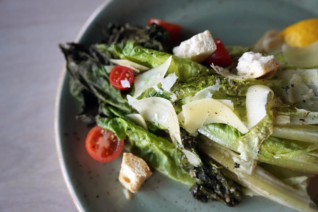 Grilled Caesar salad with romaine, tomatoes, croutons, Parmesan, lemon.