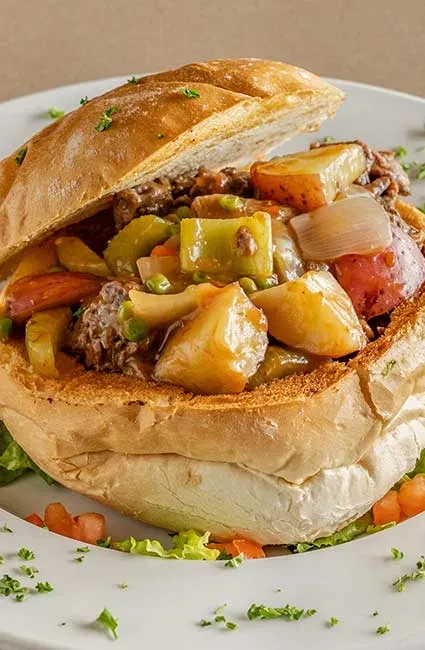 Hearty meat and vegetable stew served in a rustic bread bowl.