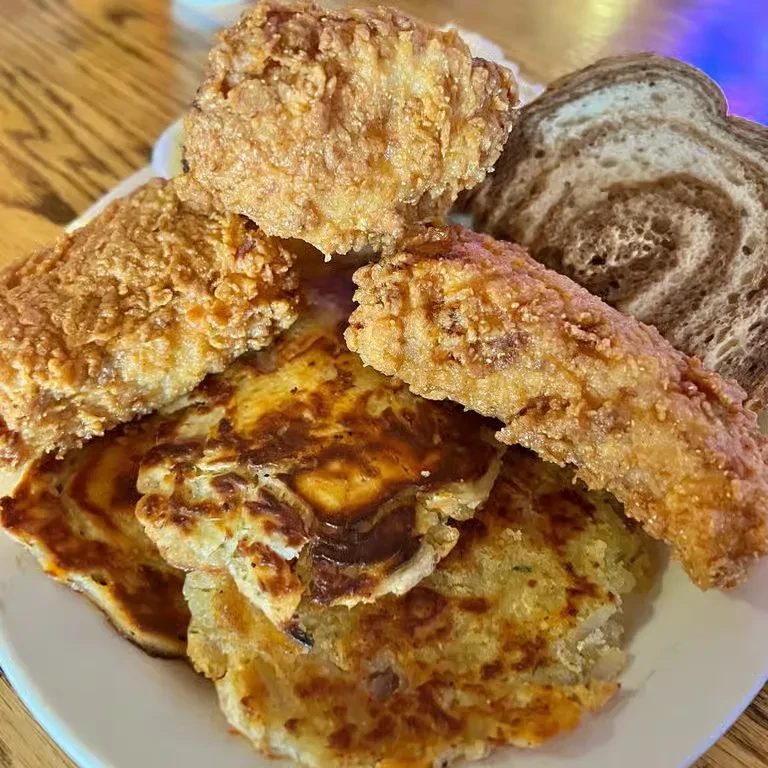 Crispy fried food, latkes, and marbled rye on a plate.
