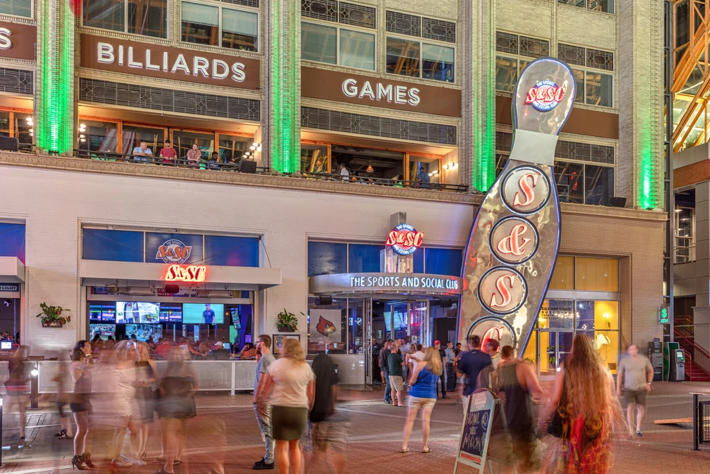 Vibrant multi-level Sports and Social Club at night with bowling pin.