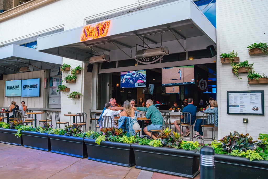 S&SO sports bar exterior with patrons on patio and inside.