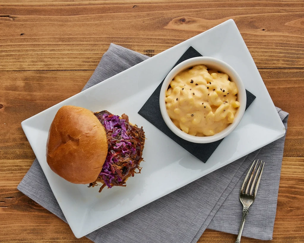 Overhead: Pulled meat sandwich, purple slaw, and mac and cheese.