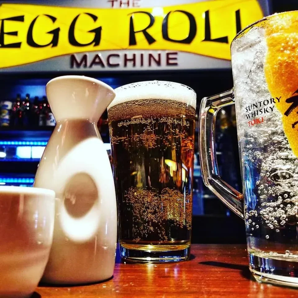 Close-up of sake, beer, and Suntory Toki highball at a modern bar.