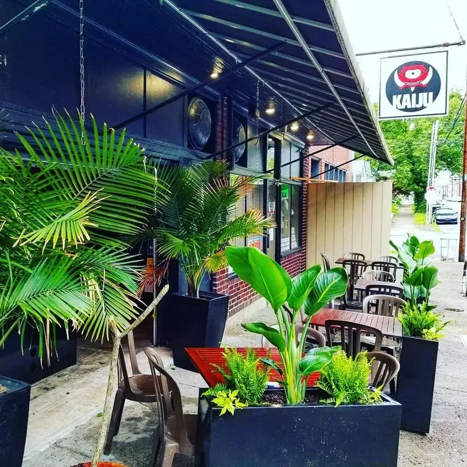 KAIJU restaurant exterior with lush, tropical outdoor patio seating.